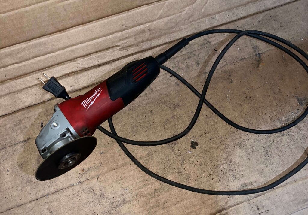 Milwaukee corded angle grinder in a garage